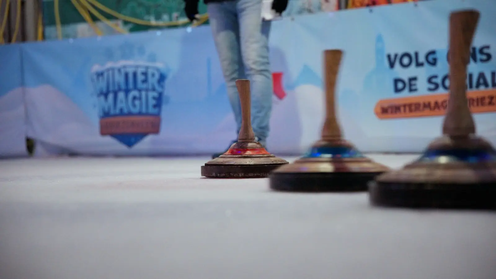 Curlingstenen op het ijs voor het WinterMagie-doek